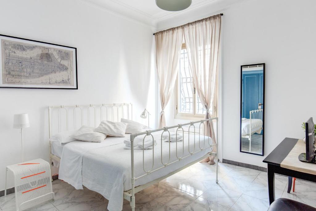a white bedroom with a white bed and a window at Locanderia Roma in Rome