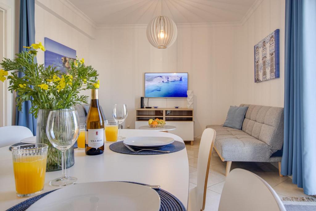 Old Town 2BR 50m Ocean w/ AC Wi-Fi Parking Terrace في ألبوفيرا: غرفة معيشة مع طاولة مع زجاجة من النبيذ