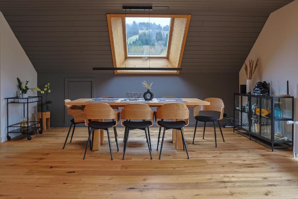 上斯陶芬的住宿－Edelschwarz Allgäu，餐桌、椅子和窗户