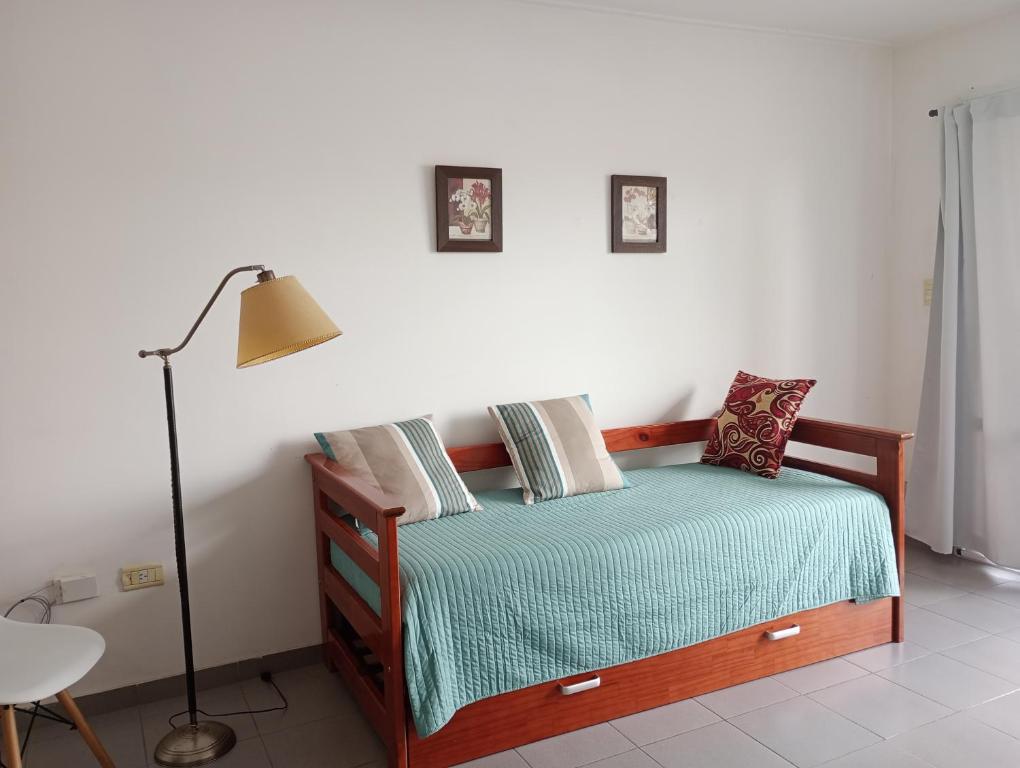 a bedroom with a bed with a lamp and pillows at Hogareño departamento calle 42 in La Plata