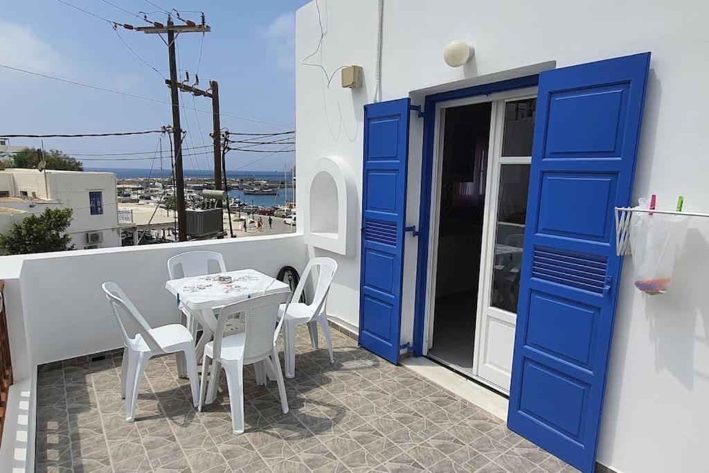 una puerta azul y una mesa y sillas en el balcón en Larinaki's Cozy Apartment No1, en Órmos Aiyialís