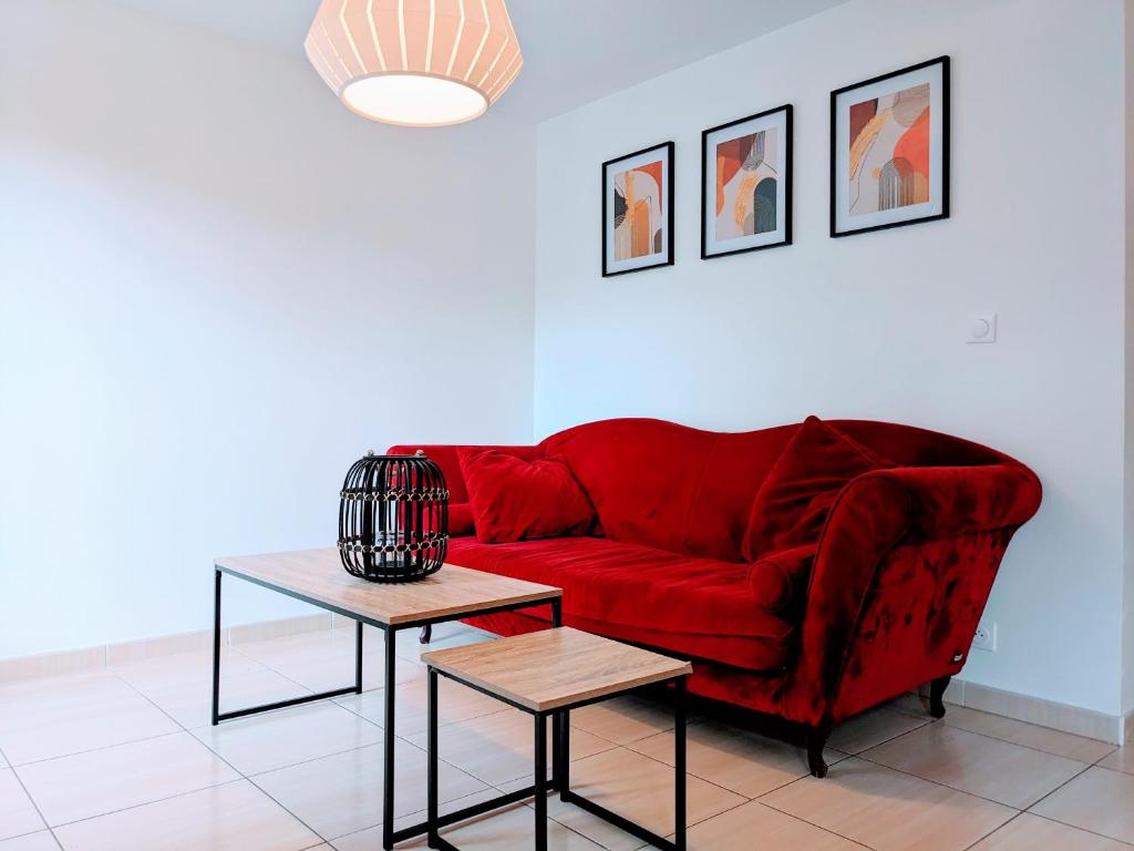 - un canapé rouge dans un salon avec deux tables dans l'établissement Chambre cosy en colocation dans une maison, à Champs-sur-Marne