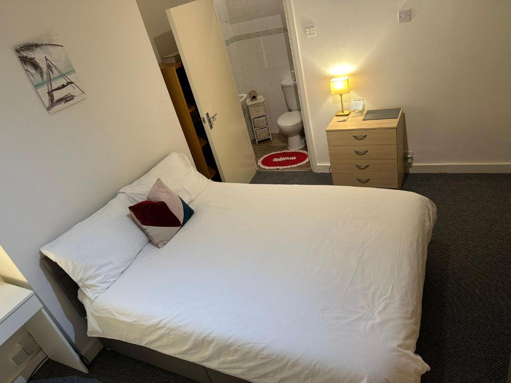 a small bedroom with a white bed and a bathroom at Suite double room in Tottenham. in London