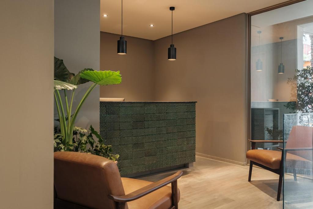 a living room with a chair and a plant at Casa Cibeles by Lumina in Mexico City