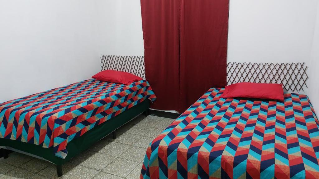 - deux lits assis l'un à côté de l'autre dans une pièce dans l'établissement Casa de descanso Grace, à Puerto San José