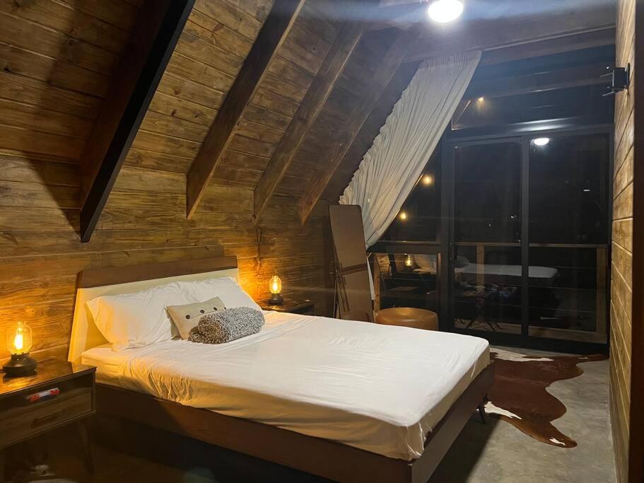 1 dormitorio con cama y ventana grande en Los Helechos 5M en Jarabacoa