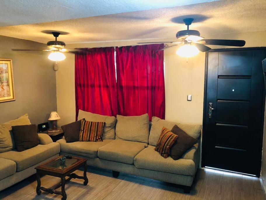 a living room with a couch and a red curtain at CASA ENTERA CERCA DE PRINCIPALES VIAS EN TIJUANA in Tijuana