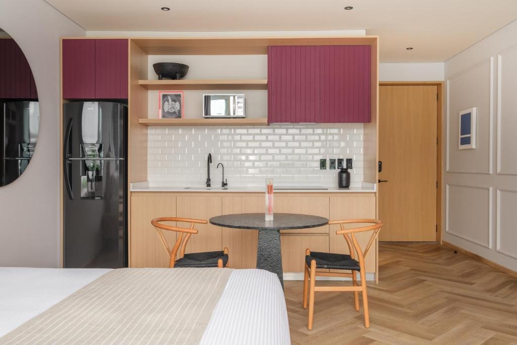 a kitchen with a table and chairs in a room at Casa Cibeles by Lumina in Mexico City