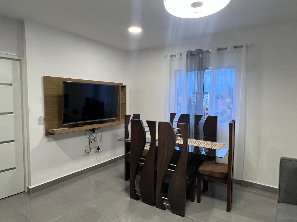 a dining room with a table with chairs and a television at Papillo Tower in Bayahibe