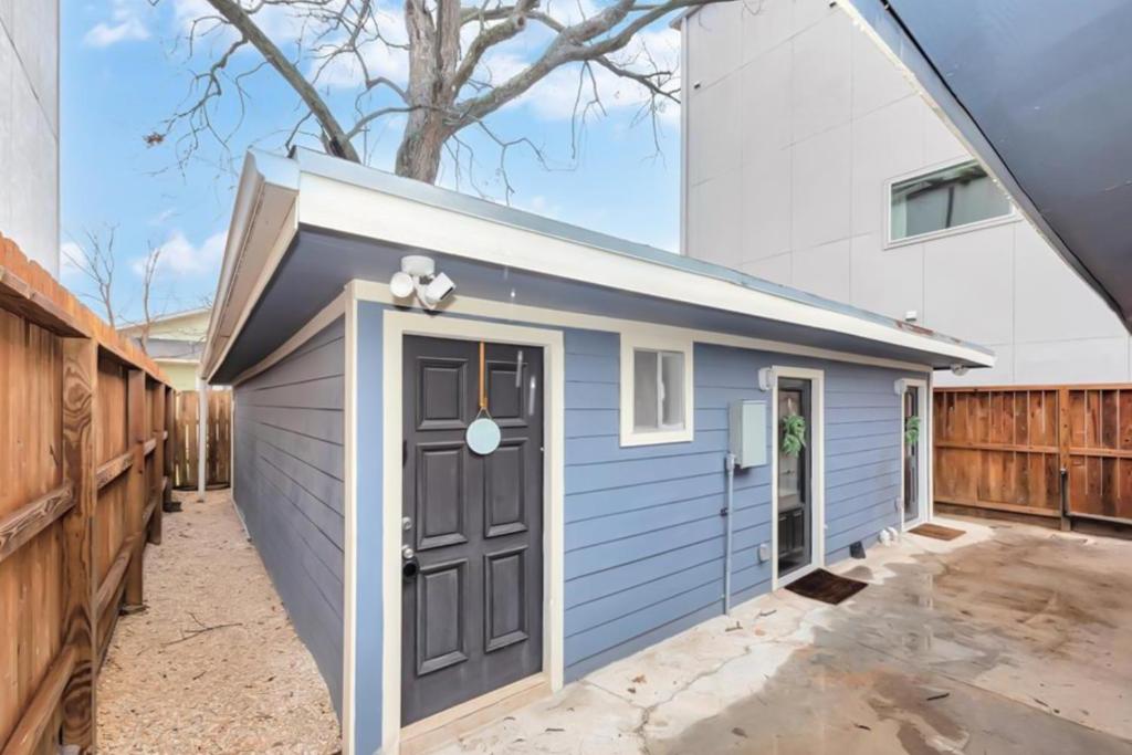 a blue garage with a door and a tree at Houston Hideaway - Unit C in Houston