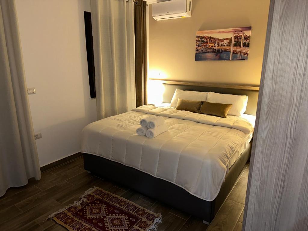 Un dormitorio con una cama con un osito de peluche. en Te Gjyshi, en Berat