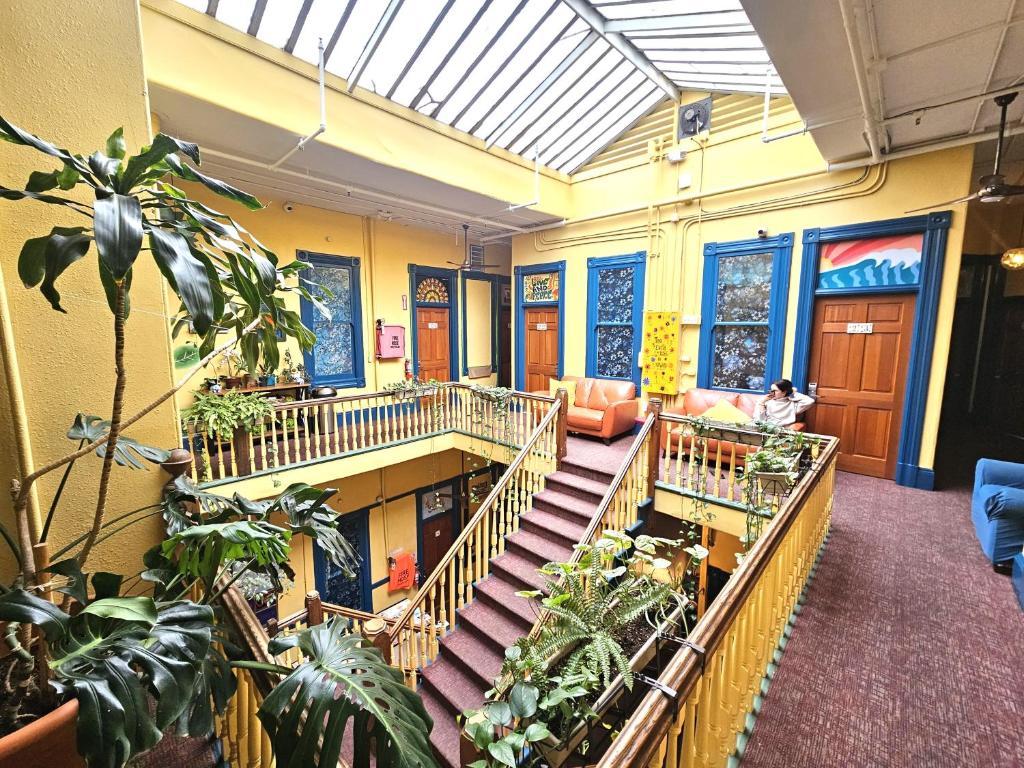 a lobby with stairs and plants in a building at Gaslamp Hostel in San Diego