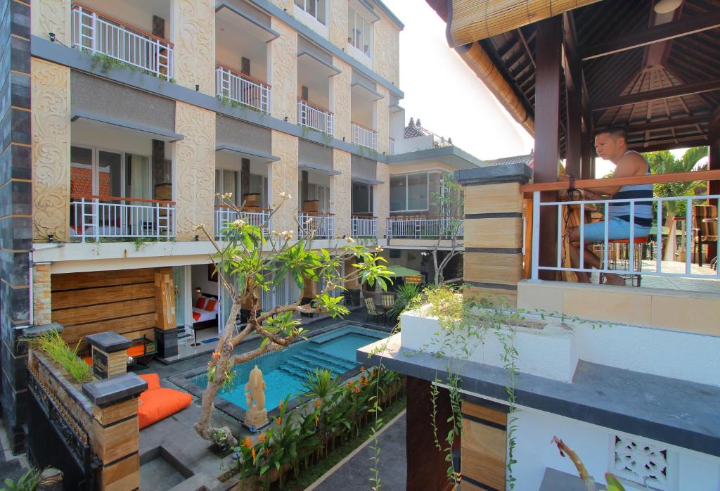 an external view of a hotel with a swimming pool at Lotus Tirta Seminyak in Seminyak