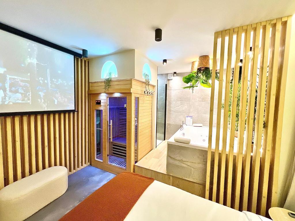 une grande salle de bain avec une baignoire et un lavabo dans l'établissement Spa - Sauna privatif plein centre, à Troyes