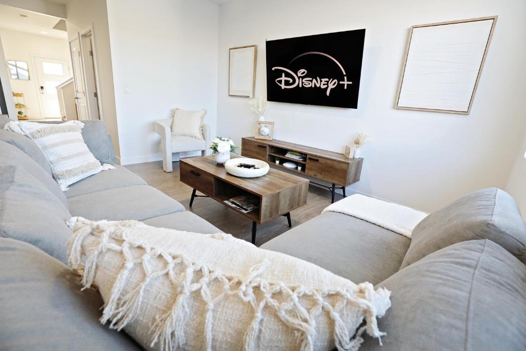 uma sala de estar com um sofá e uma mesa em BoHo Retreat with King Beds, Golf, Disney+, Near WEM em Edmonton