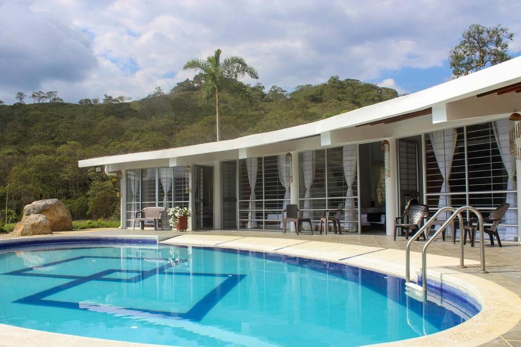 una grande piscina di fronte a una casa di CASA MERAK - Inspira tu vida a Oiba