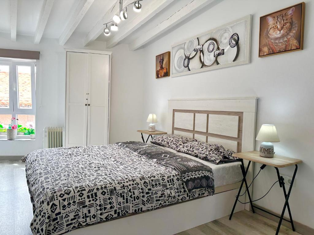 a bedroom with a black and white bed and two tables at Casa Ekaterina de Novelda in Novelda