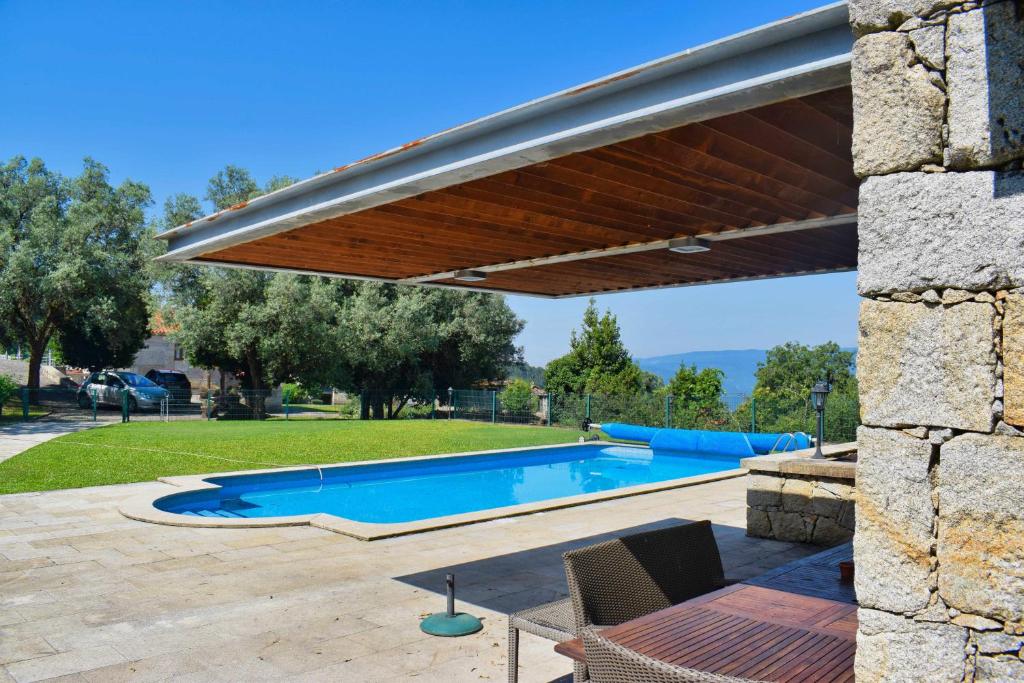 awning over a swimming pool in a yard at Casa Cabo da Eira in Arcos de Valdevez