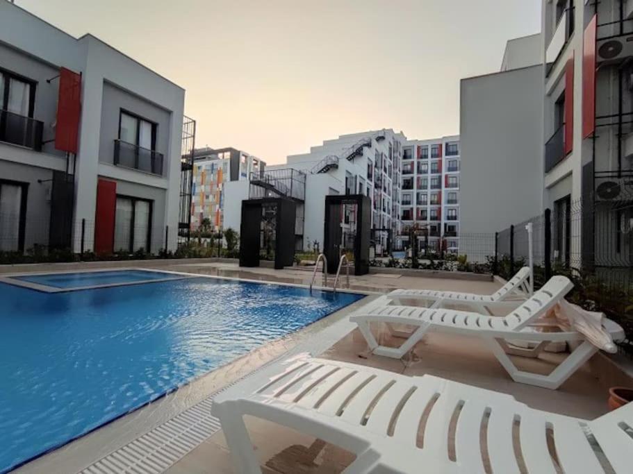 a swimming pool with two lounge chairs and a swimming pool at Comfort and Peace in a Luxury Residence! in Antalya