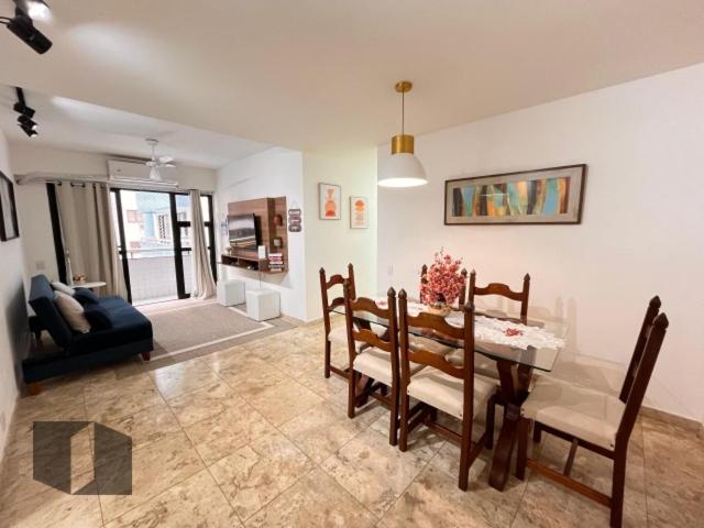 uma sala de estar com uma mesa de jantar e cadeiras em Excelente Apartamento no Leblon 02 quadras da praia em prédio com piscina, sauna e academia no Rio de Janeiro