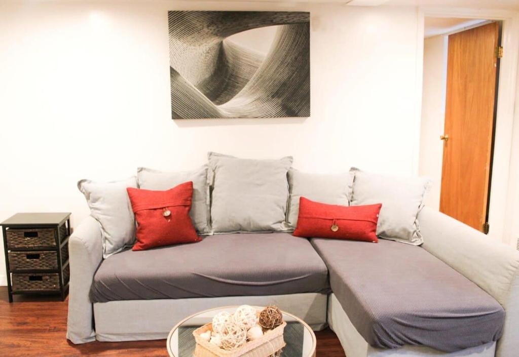 a couch with red pillows in a living room at 1 Bed Apt - Amazing Location 1 Block to Carson St in Pittsburgh