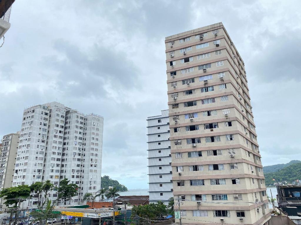 two tall white buildings in a city at Pé na Areia Praia do Gonzaguinha in São Vicente