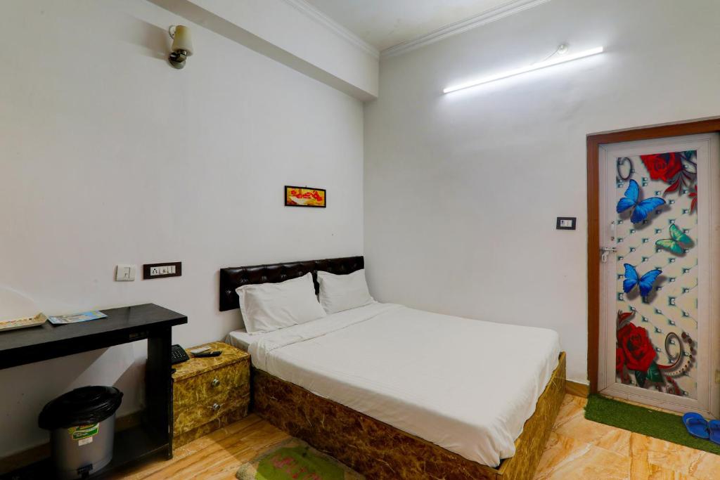a small bedroom with a bed and a desk at OYO Xpress Home in Lucknow