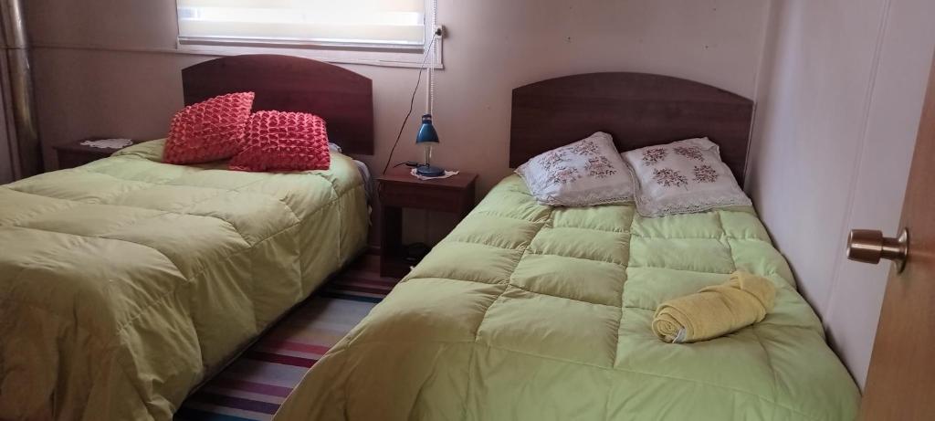 twee bedden naast elkaar in een kamer bij hospedaje familiar Esperanza in Coihaique