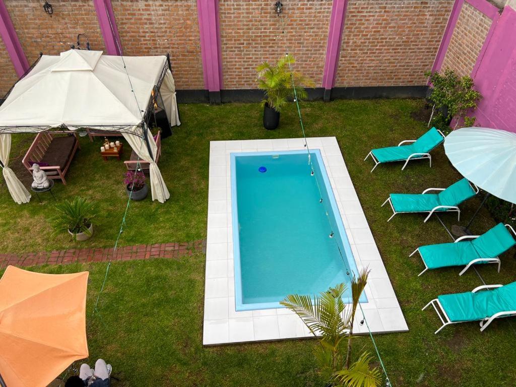 a backyard with a swimming pool and chairs and umbrellas at AM Hotels Collect in Arequipa