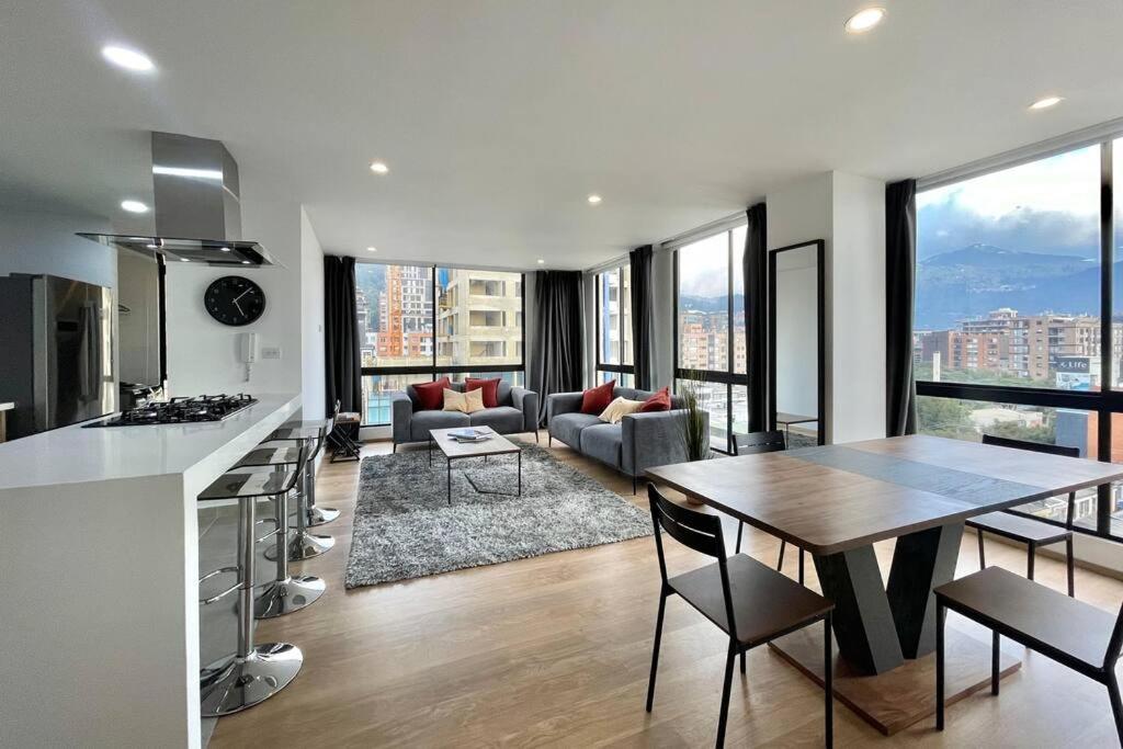 eine Küche und ein Wohnzimmer mit einem Tisch und einer Couch in der Unterkunft SkyLine Mountains Sauna Gym Luxury Apto in Bogotá
