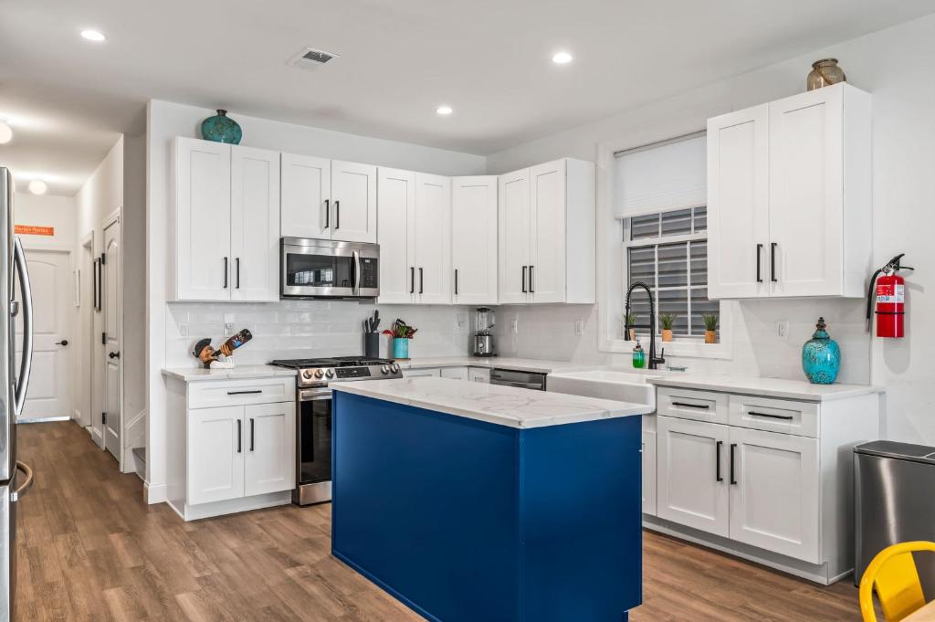 a kitchen with white cabinets and a blue island at Beach House Steps away from the Boardwalk and Beach with Ocean Views in Seaside Heights! in Seaside Heights