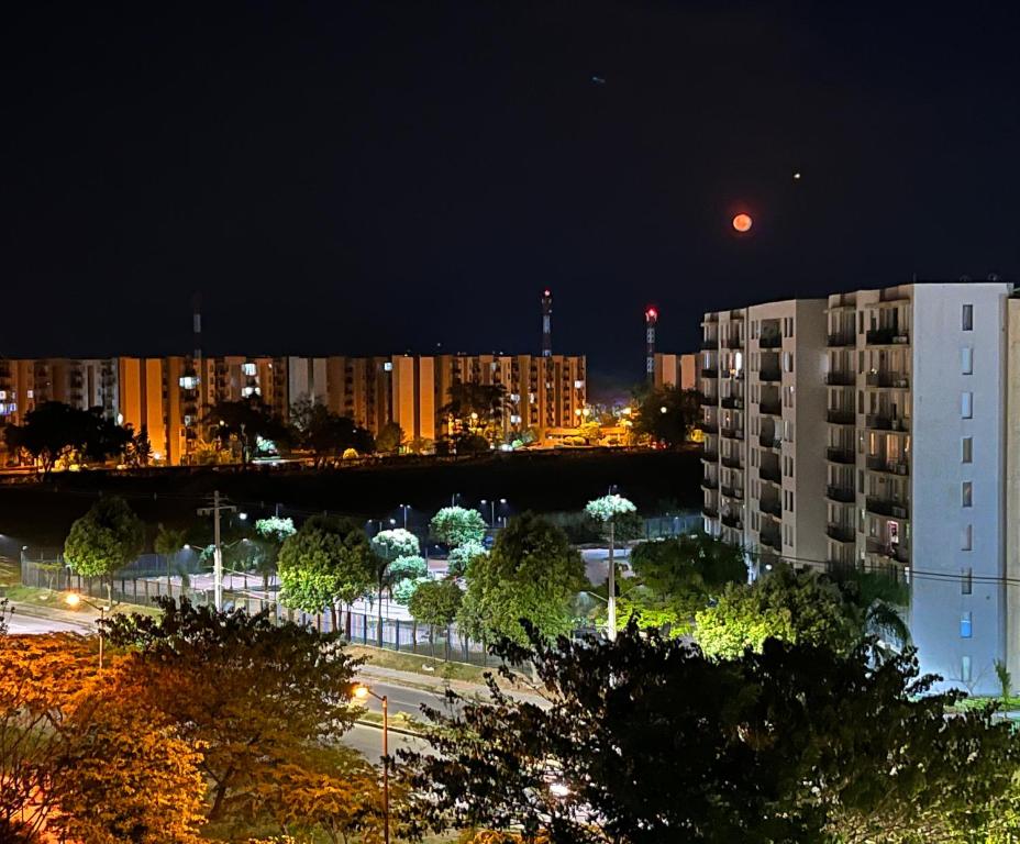 a view of a city at night with the moon at Comfortable Apto en Hacienda Peñalisa in Ricaurte