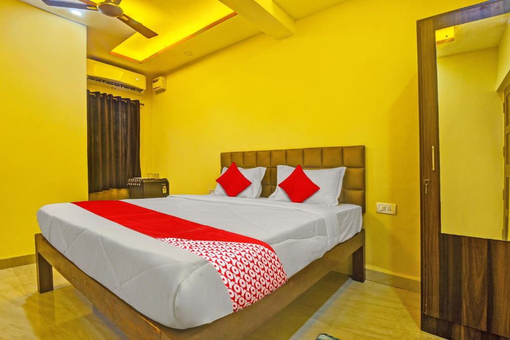 um quarto com uma cama grande e almofadas vermelhas em OYO Flagship Peppy Guest House em Calangute