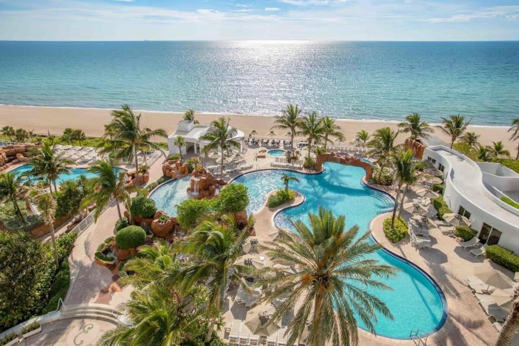 an aerial view of a resort with a swimming pool and the beach at 21st Floor Luxury Suite at Trump Int Resort in Miami Beach
