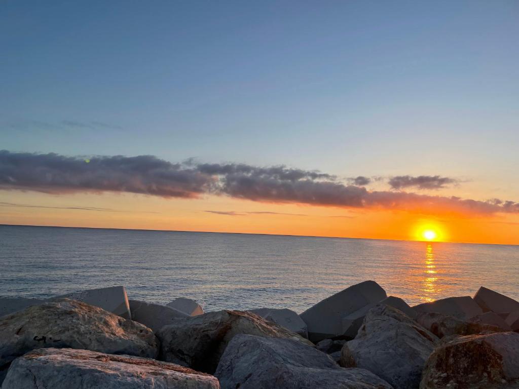 - un coucher de soleil sur l'océan avec de grands rochers dans l'établissement Le coup de cœur d’Argelès, à Argelès-sur-Mer