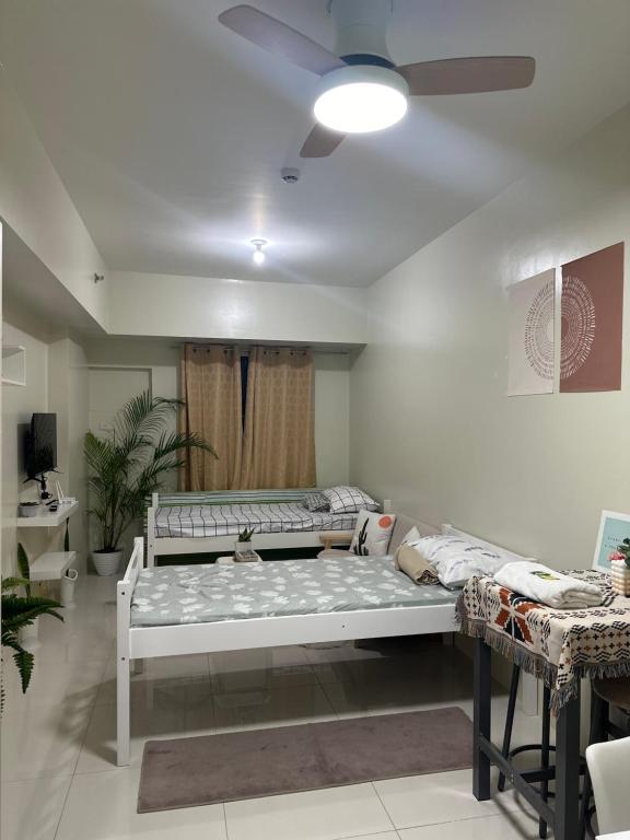 een kamer met 2 bedden en een plafondventilator bij Family room at Brenthill Condo Near SM and Botanical Garden in Baguio