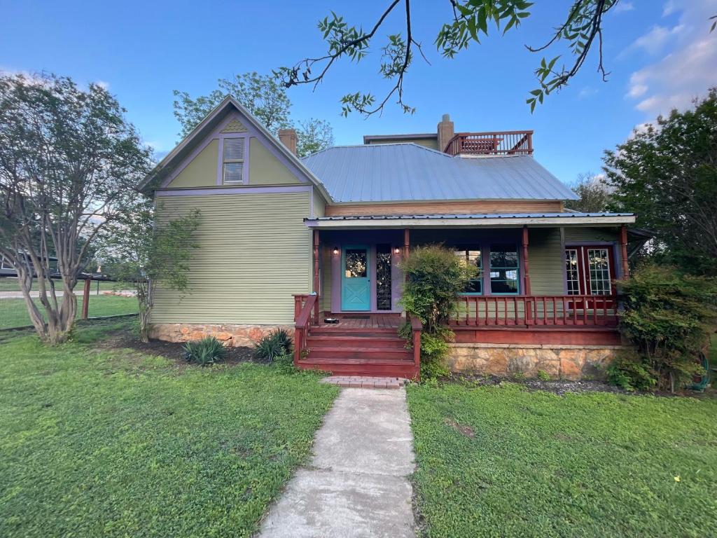 une maison avec une porte rouge et une terrasse couverte dans l'établissement 311 Sunflower, à Marble Falls