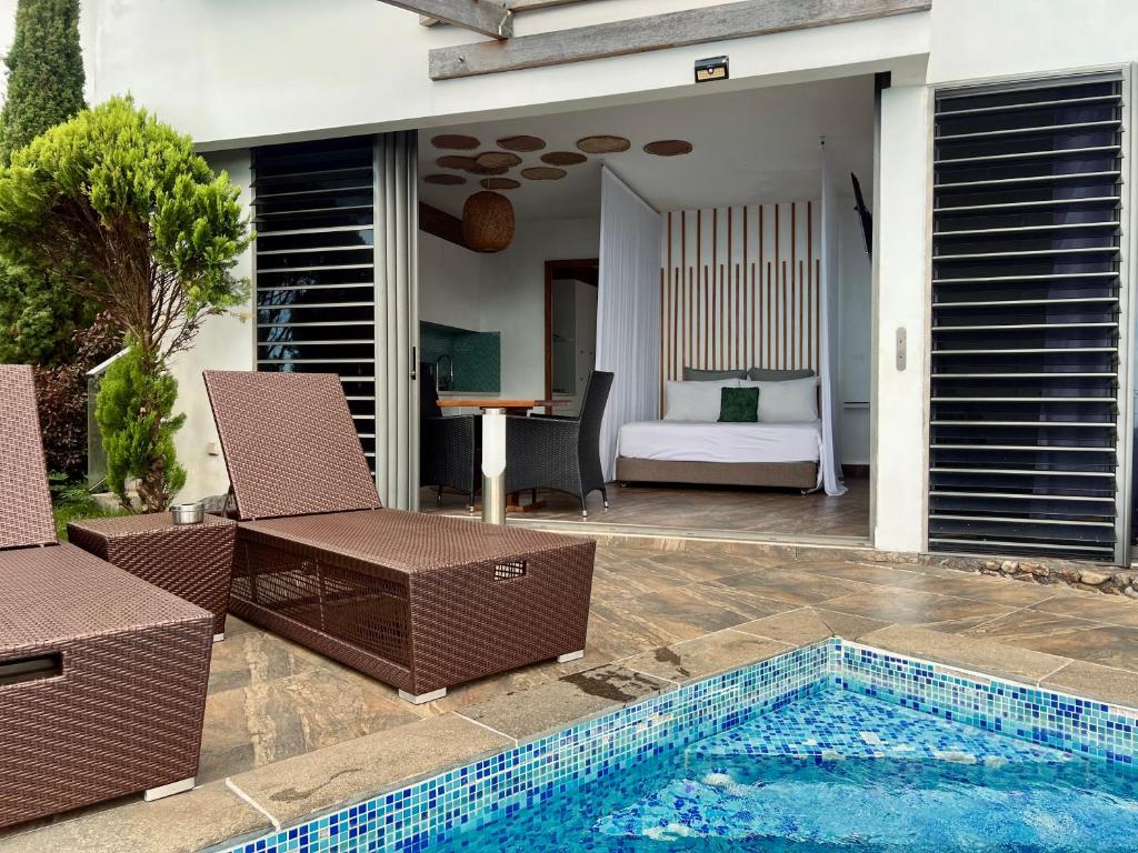 a villa with a swimming pool and a bedroom at Suite by the Pool in Faaa