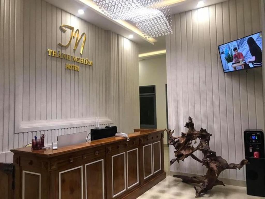 um átrio com uma recepção e uma televisão na parede em Thành Nghiêm Hotel Ninh Hòa em Ninh Hòa