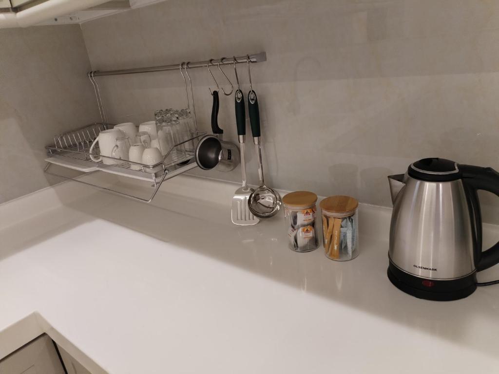 a kitchen counter top with a coffee pot and utensils at شقق الياسمين in Al Madinah