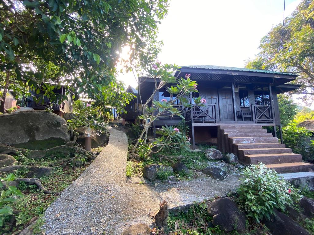 ein kleines Haus mit Treppen, die dorthin führen in der Unterkunft Nazri's Place 2 in Tioman Island