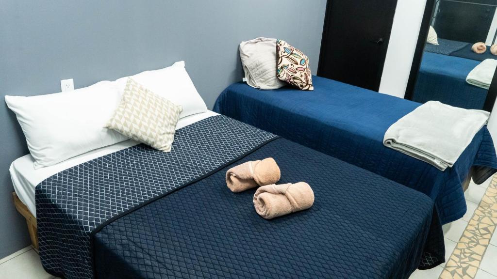 dwa łóżka z kapeluszami w pokoju w obiekcie Casa Salazar Guadalajara w mieście Guadalajara