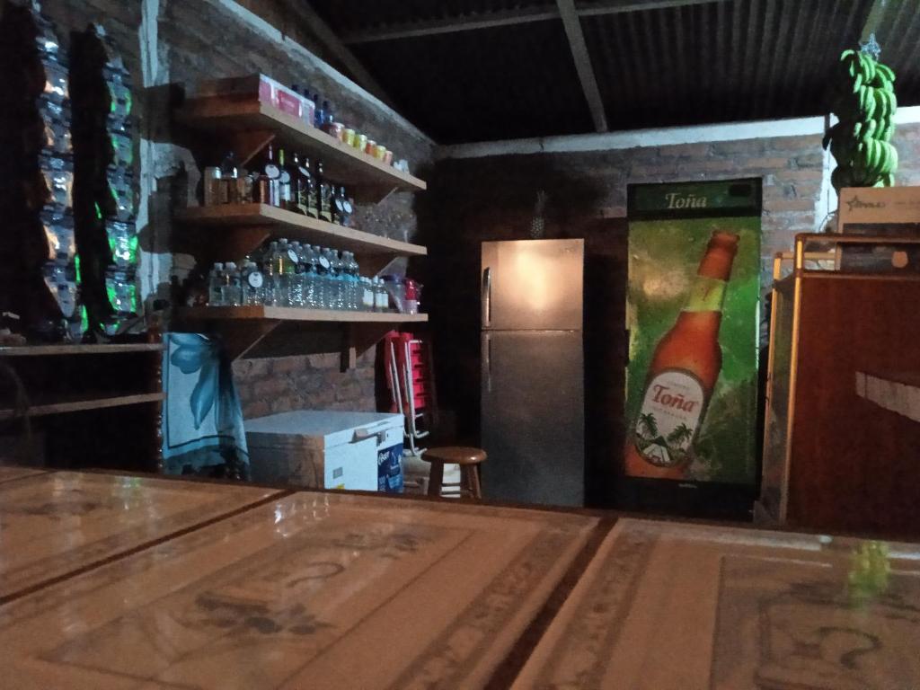 un bar con una botella de cerveza y una nevera en Restaurante El Escondite en Ometepe