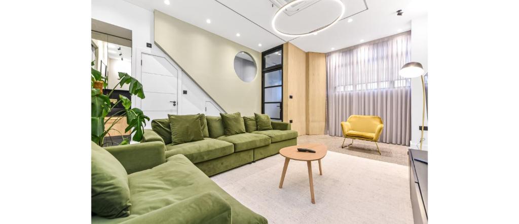 a living room with a green couch and a table at Luxury Abode: 5-Bed Haven Ideal for Big Groups! in London