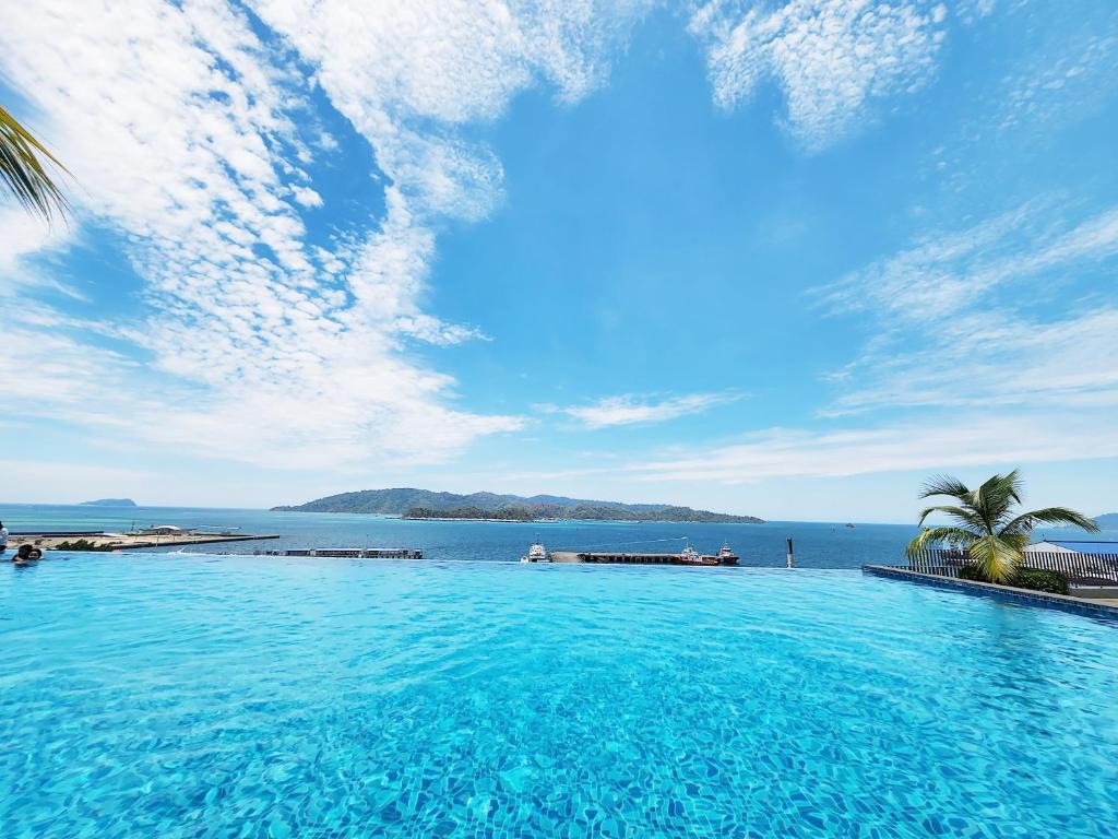 a large swimming pool with a view of the ocean at Jesselton Quay Kota Kinabalu City Centre by LW Suites in Kota Kinabalu
