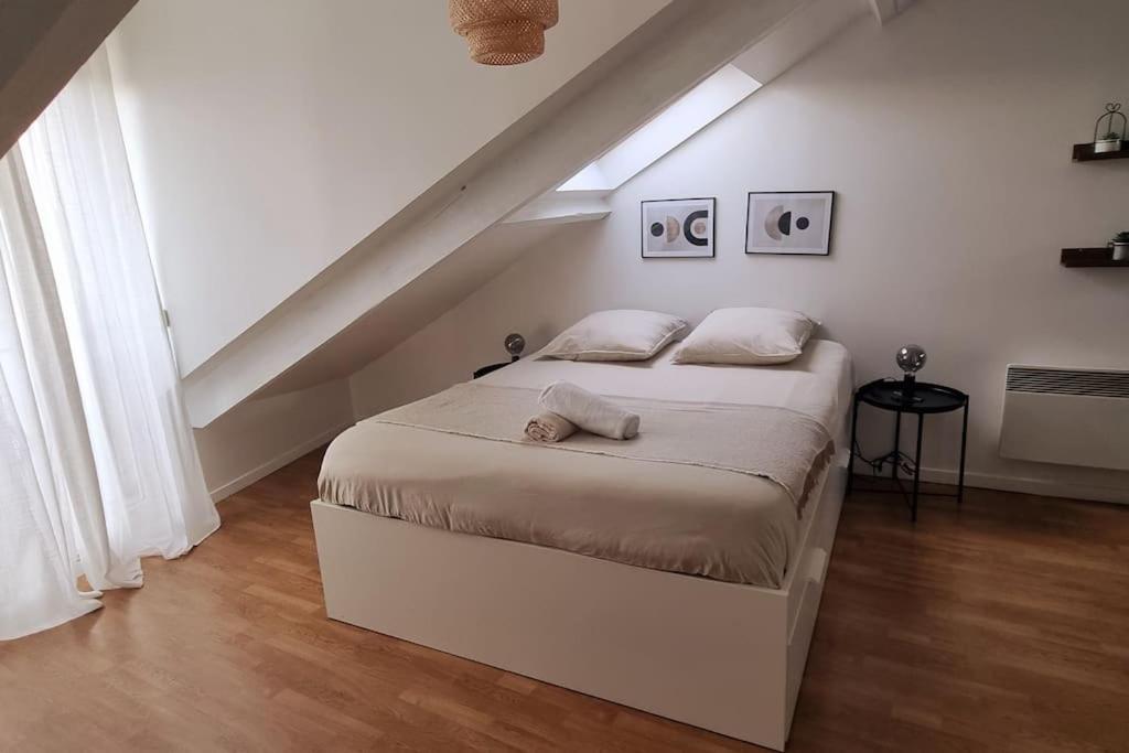 ein weißes Schlafzimmer mit einem Bett im Dachgeschoss in der Unterkunft Accès rapide 10' de Disney & 30' de Paris - Proche gare & bus in Esbly