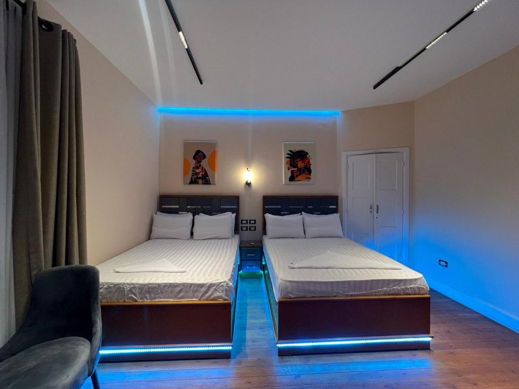 2 Betten in einem Zimmer mit blauer Beleuchtung in der Unterkunft Space Hostel in Kairo