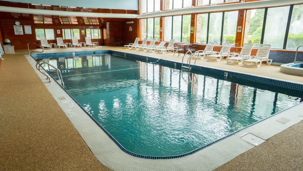 a large swimming pool with chairs in a building at The Mariner Resort Cape Cod by The Red Collection in West Yarmouth