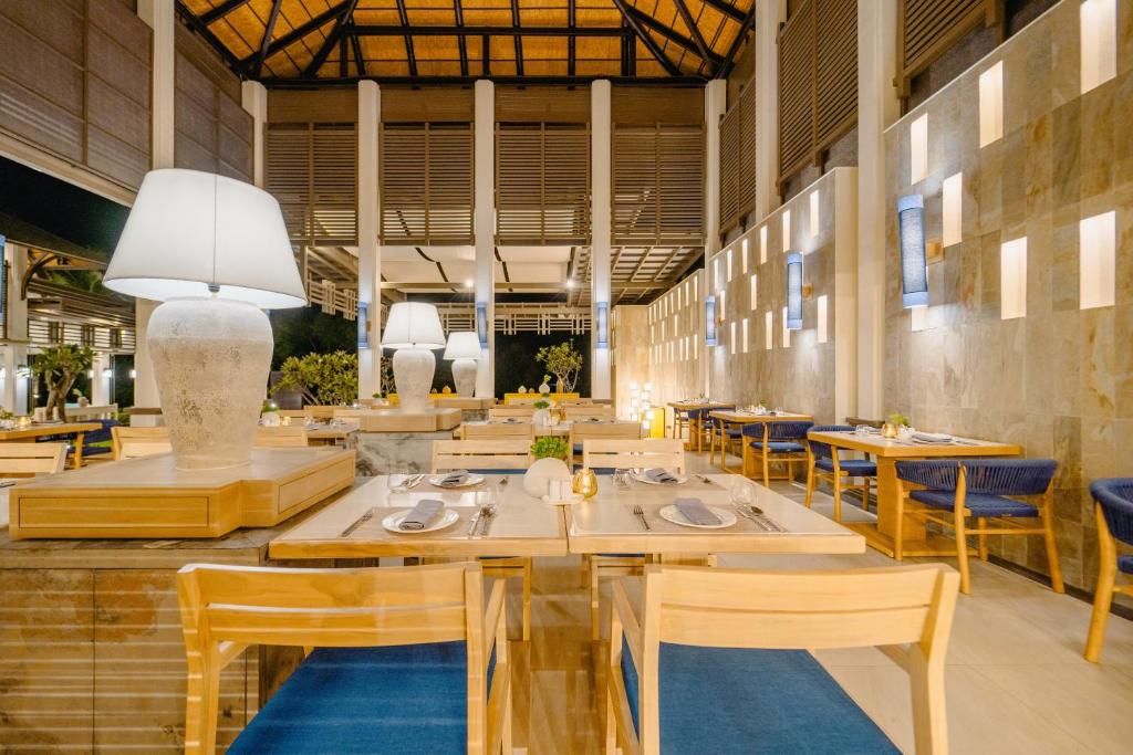 a dining room with wooden tables and chairs at Bhu Nga Thani Resort & Villas Railay in Railay Beach
