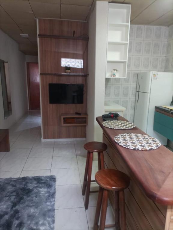 una cocina con barra y dos taburetes. en Cantinho Aconchego, en Santo Antônio do Pinhal